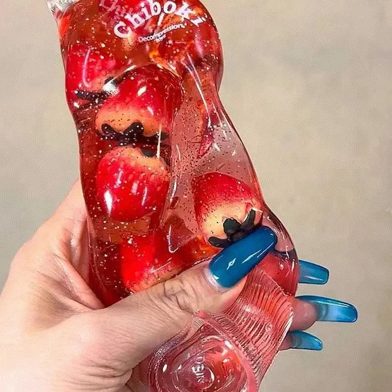 Hand holding a Chiboki strawberry tube with red strawberries on a white background