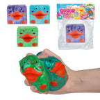 Green glittery duck-shaped squishy toy with orange beak and feet, held in a hand, with packaging in the background.