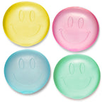 Four smiley face-shaped squishies in yellow, pink, blue, and green on a white background.