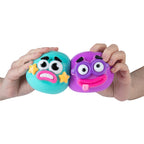 Two colorful emoji-like smusher stress balls held by hands against a white background