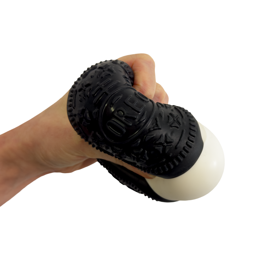 Hand holding a black massage tool with textured surface on a white background