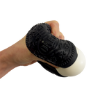 Hand holding a black massage tool with textured surface on a white background