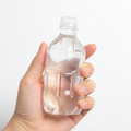 Hand holding a clear water bottle shaped squeeze toy