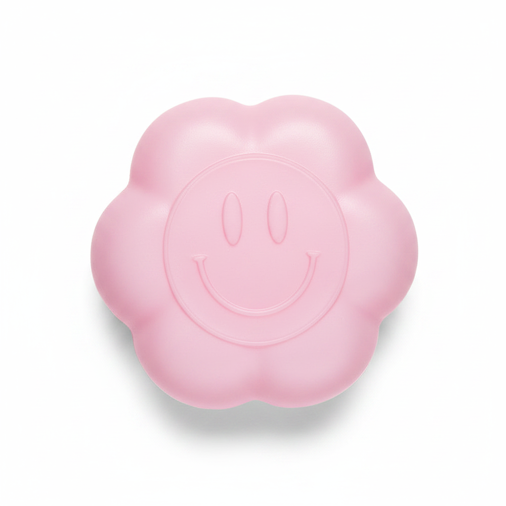 Pink daisy squishy toy with smiley face on white background