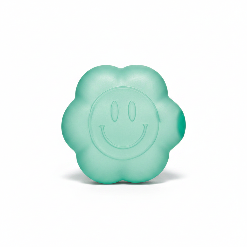 Teal daisy squishy toy with smiley face on white background