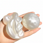Pearl white stress ball squeezed flat showing softness